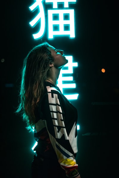 女人穿黑色和白色夹克站在面对她的左边
